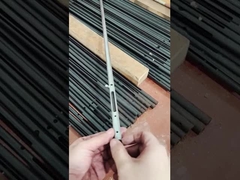 Un homme montre un petit composant en acier au carbone.